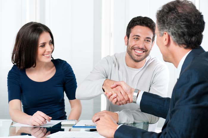 Man and woman shaking hands with customer success advisor